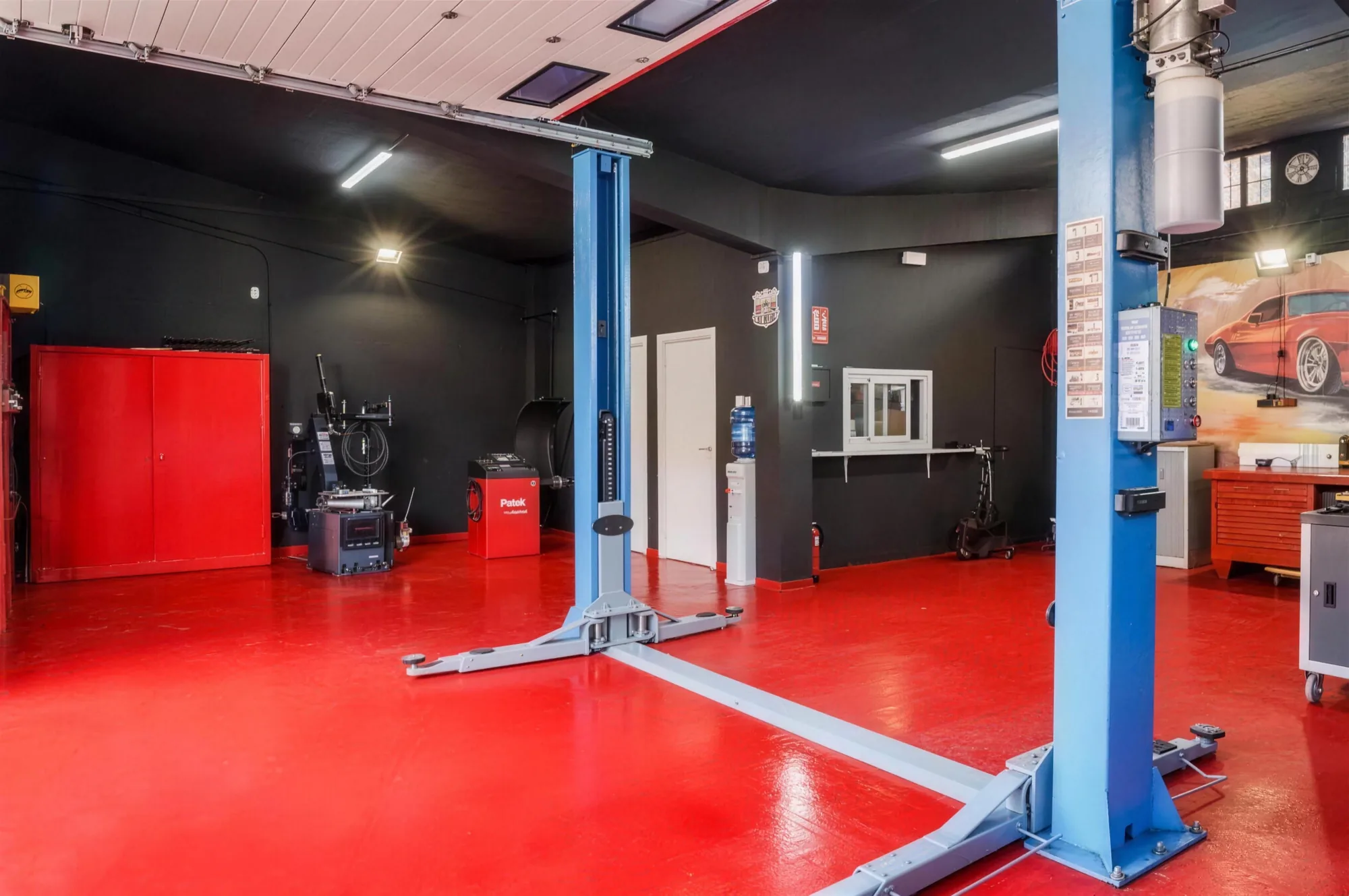 Interior de Talleres Bhe: instalaciones ordenadas con elevadores de coche